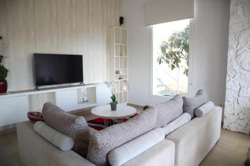 a living room with a couch and a tv at Guardamar Sea View Villa in Guardamar del Segura
