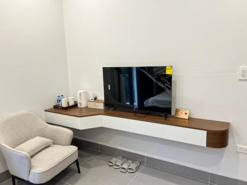 sala de estar con TV y silla en Tea hotel by Chiến Hảo, en Ha Giang