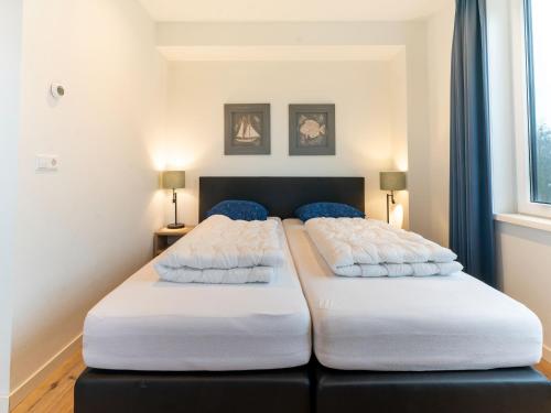 two beds sitting next to each other in a bedroom at Pretty Holiday Home in De Koog Texel with Garden in Westermient