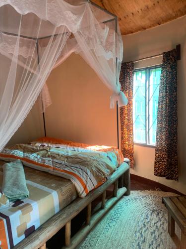 a bedroom with a bed with a canopy at Furahia Eco Inn in Usa River