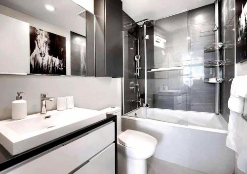 ein Badezimmer mit Waschbecken, Toilette und Dusche in der Unterkunft AltitudeOne - Downtown Montreal Penthouse & Condo - Pool Spa Parking in Montreal