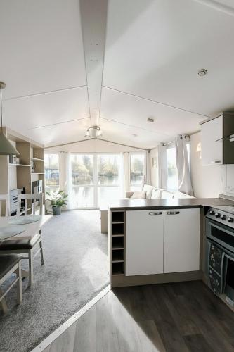 a large kitchen with white cabinets and a table at Billing Aquadrome - Bird Lake View in Great Billing