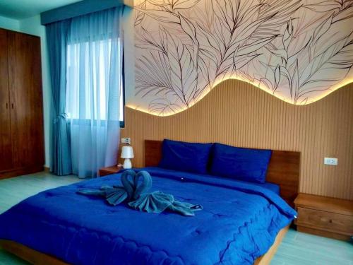 - une chambre dotée d'un lit bleu et d'une peinture murale dans l'établissement Goldena Residence Pool Villas, à Kamala Beach