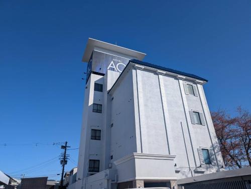 a white building with an ak sign on it at ホテルAO男塾ホテルグループHimeji in Himeji