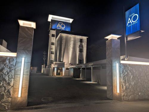 a lit up building at night with aaa signs on it at ホテルAO男塾ホテルグループHimeji in Himeji