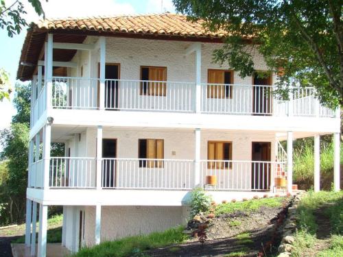 a white building with balconies on the side of it at Hotel Ecoturistico Villa Lucy in Curití