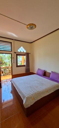 een slaapkamer met een groot bed met paarse kussens bij Smart View Guesthouse 