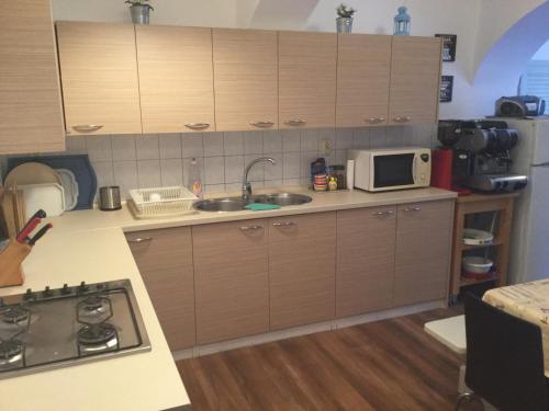 a kitchen with a sink and a microwave at Avas Apartman in Miskolc