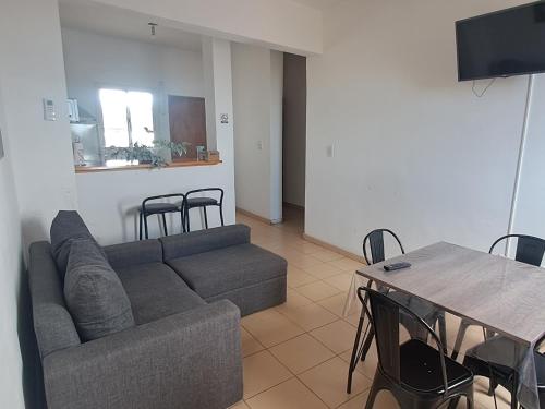 a living room with a couch and a table with chairs at Sol y Malbec Departamentos in Guaymallen