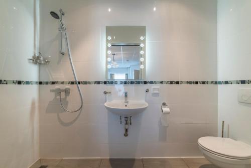 a bathroom with a sink and a toilet at B&B Groene Meent in Leerdam