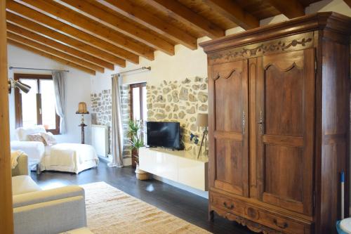 a living room with a large wooden cabinet at Batxillerenea in Doneztebe