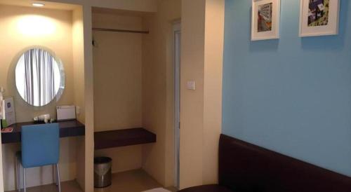 um banheiro com uma pia e um espelho em C2 Residence Hotel em Sathani Nakhon Lampang