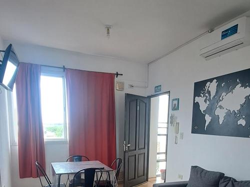 a room with a table and a window and a door at Sol y Malbec Departamentos in Guaymallen