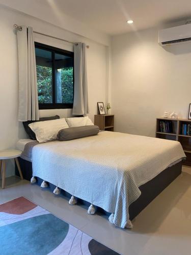 a bedroom with a large bed with a window at Green & Pink Garden Homes in Ko Phangan