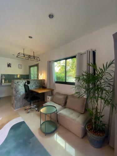een woonkamer met een bank en een tafel bij Green & Pink Garden Homes in Ko Phangan