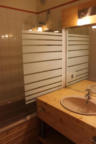 une salle de bain avec un lavabo et un miroir dans l'établissement Eterlous Appartements VTI, à Val Thorens