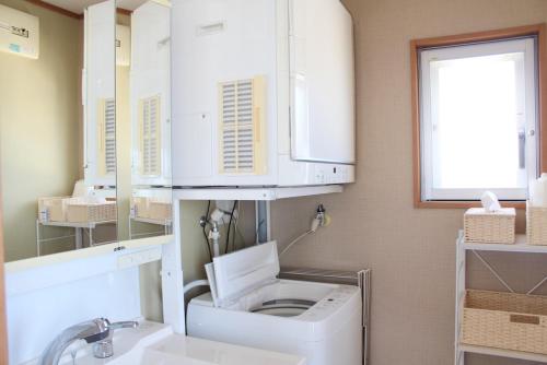a bathroom with a sink and a toilet and a mirror at 全室オーシャンビュー外階段付き一棟貸切プライベートヴィラ in Kouri