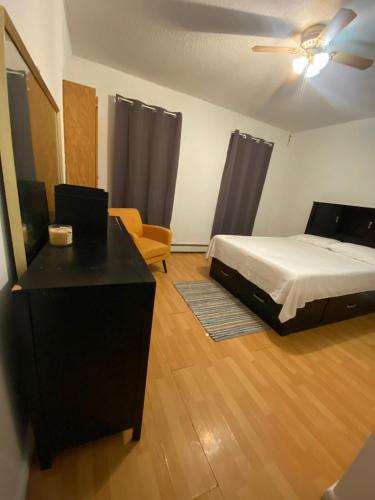 um quarto com uma cama, uma escrivaninha e uma cadeira em private room em Paterson