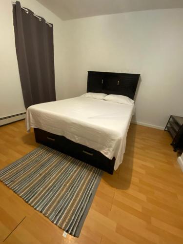 uma cama num pequeno quarto com um tapete em private room em Paterson