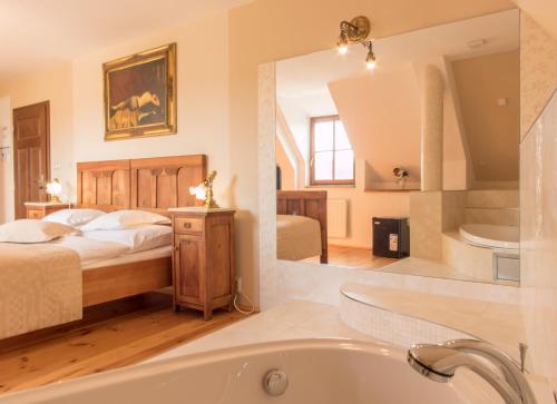 uma casa de banho com uma banheira e um quarto com uma cama em Boutique hotel Pracháreň em Levoča