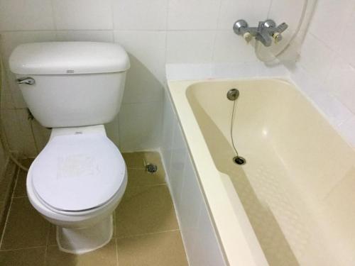 une salle de bain avec toilettes et baignoire dans l'établissement Arcadia Mansion, à Pattaya