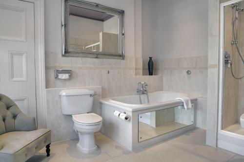 a bathroom with a toilet and a sink and a mirror at Pontlands Park Hotel in Chelmsford