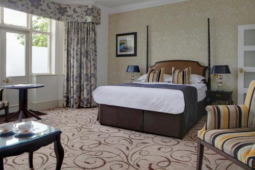 a hotel room with a large bed and a couch at Pontlands Park Hotel in Chelmsford