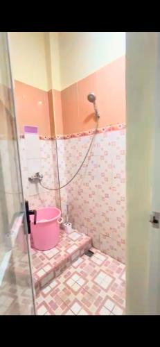 La salle de bains est pourvue d'une douche avec un seau rose. dans l'établissement SIJI Homestay Purwokerto, à Purwokerto