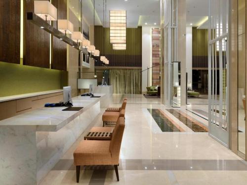 Un vestíbulo con sillas y un bar en un edificio. en Xiamenair Maple Hotel (Xiamen SM City Plaza), en Xiamen