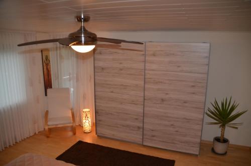 a room with a wooden sliding door and a ceiling fan at Lorettablick in Sonnenberg-Winnenberg