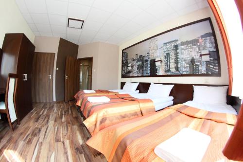a hotel room with two beds and a large screen at Hotel Mieszko in Rzeszów