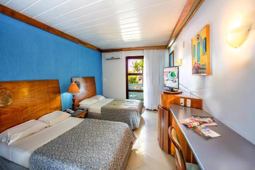 una camera d'albergo con due letti e una televisione di Resort Arcobaleno All Inclusive a Porto Seguro
