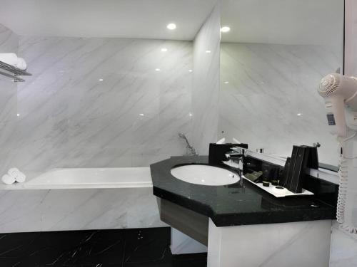 a bathroom with a sink and a black counter at pyramid suites Hotel in Banjarmasin