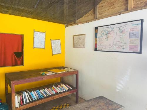 Una habitación con una estantería y un mapa en la pared. en Tina's Homestay-Tadlo, en Tad Lo