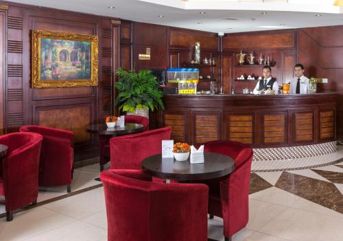 un restaurante con sillas rojas y un bar en Tourist Hotel, en Doha