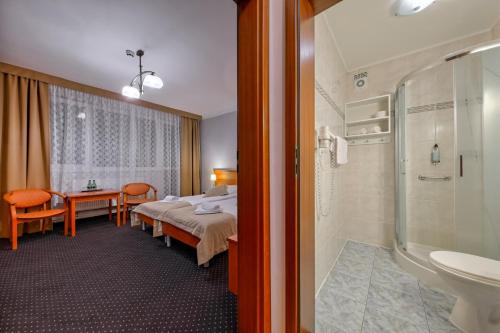 a hotel room with a bed and a bathroom at Hotel Wodnik Twój Hotel z widokiem na morze in Ustronie Morskie