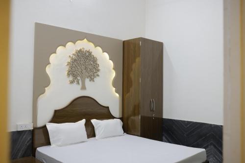 1 dormitorio con 1 cama con un árbol en el cabecero en TIRUPATI WHITE - Hotel & Restaurant, en Kekri