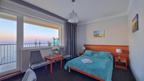 a bedroom with a bed and a view of the ocean at Hotel Wodnik Twój Hotel z widokiem na morze in Ustronie Morskie