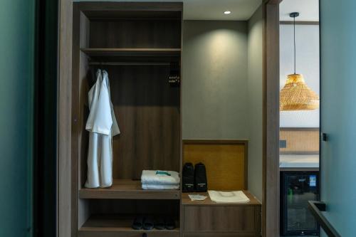 a closet with a white robe and shoes in it at Dayucang Tea Sea Cloud Inn Jingmai Ancient Tree Tea Forest Store in Mengzhe