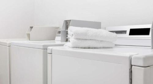 a pile of towels sitting on top of washing machines at Ramada Limited Norfolk in Greenwich