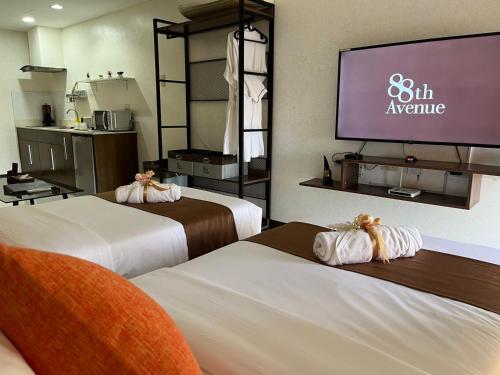 a hotel room with two beds and a projection screen at 88th Avenue in Cebu City