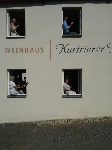 a group of people looking out the windows of a building at Weinhaus Kurtrierer Hof in Leiwen