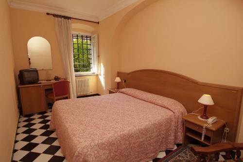 a bedroom with a bed and a desk and a window at Villa Fieschi in Lavagna