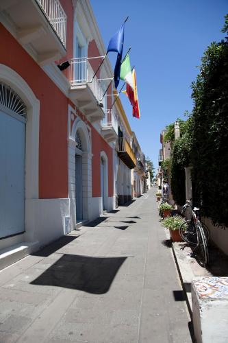 a street with two flags on the side of a building at Hotel Santa Marina Antica Foresteria in Santa Marina Salina