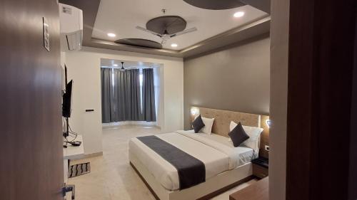 une chambre avec un grand lit et une fenêtre dans l'établissement Omnitel Kohinoor, à Udaipur