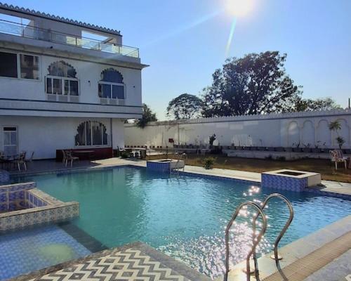 una gran piscina frente a un edificio en Omnitel Kohinoor, en Udaipur
