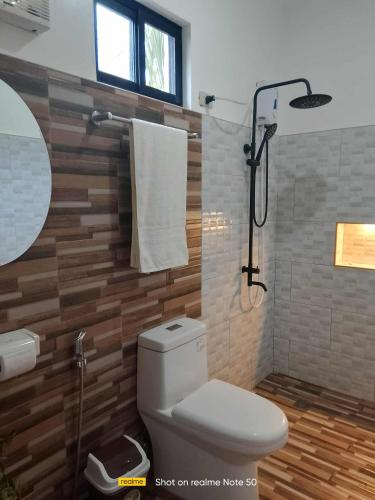 a bathroom with a toilet and a shower at Jex Poolpoint Villa in El Nido