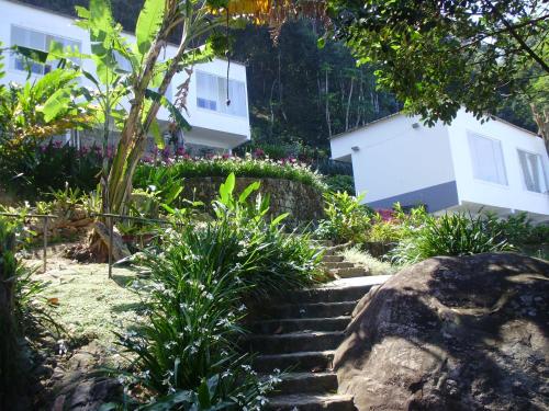 a set of stairs in front of a white building at Pousada Piquara in Mangaratiba