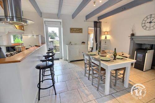 een keuken en eetkamer met een tafel en stoelen bij Ti coz in Lézardrieux
