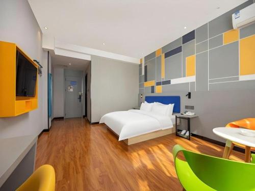 une chambre d'hôtel avec un lit et une télévision dans l'établissement 7 Days Inn Yining Xintiandi, à Yining